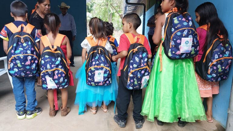 Niñas y niñios salvadoreños con mochilas de Médicos del Mundo.