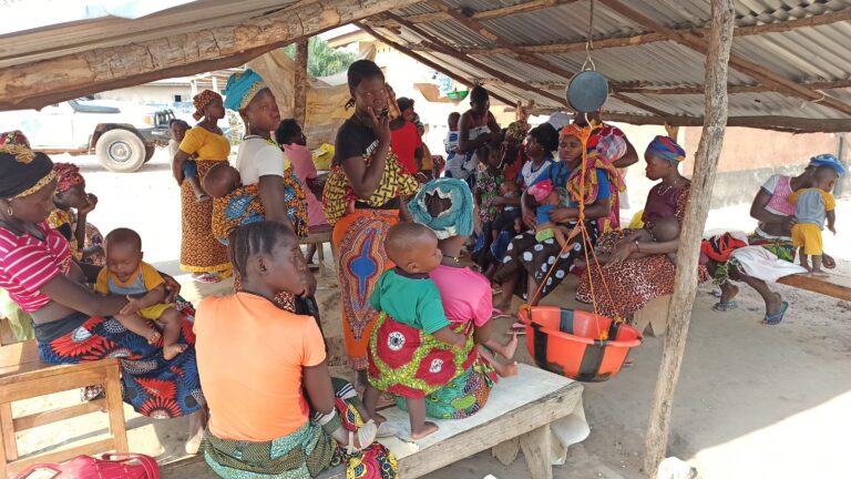 Mujeres pesando a sus hijos e hijas en Sierra Leona.