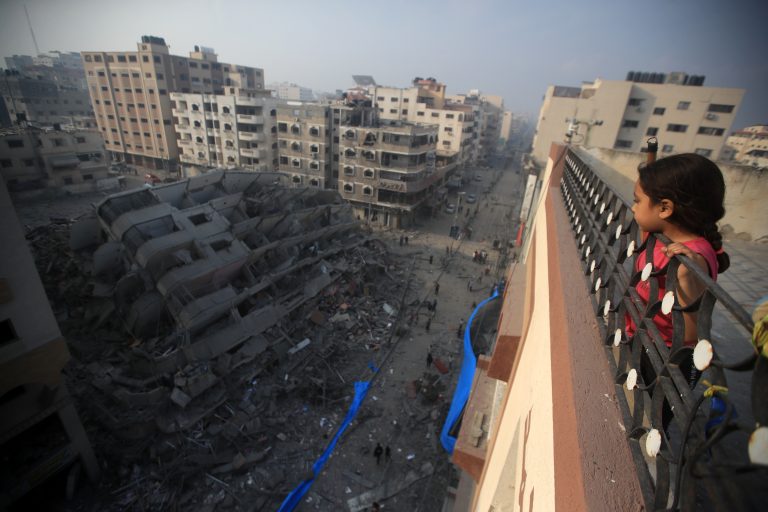 Una niña palestina observa desde lo alto de un edificio la destrucción de una torre residencial bombardeada por aviones de guerra israelíes. Consta de diez plantas y alberga a 70 familias en la calle Al-Nasr, al oeste de la ciudad de Gaza. ©Mohammed Zaanoun