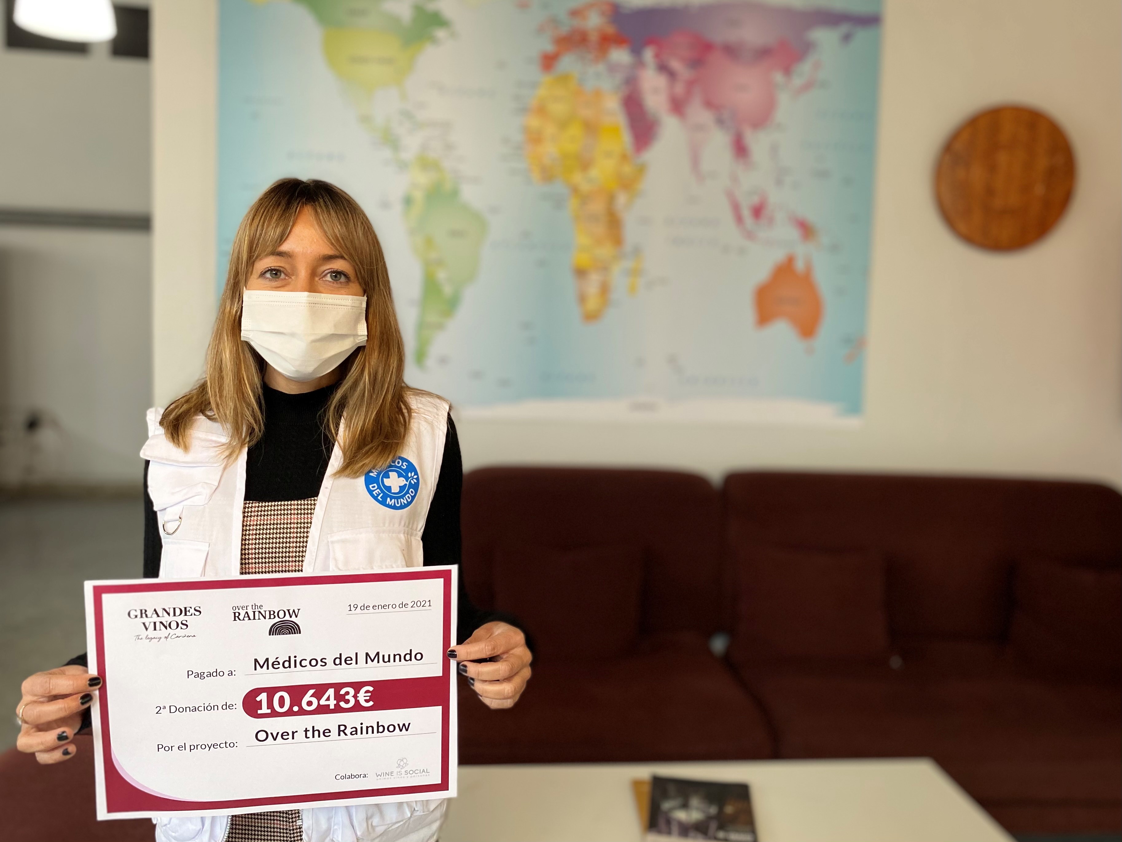 Susana Atienza, directora de Marketing de Médicos del Mundo, sostiene el cheque simbólico de la donación de Grandes Vinos.